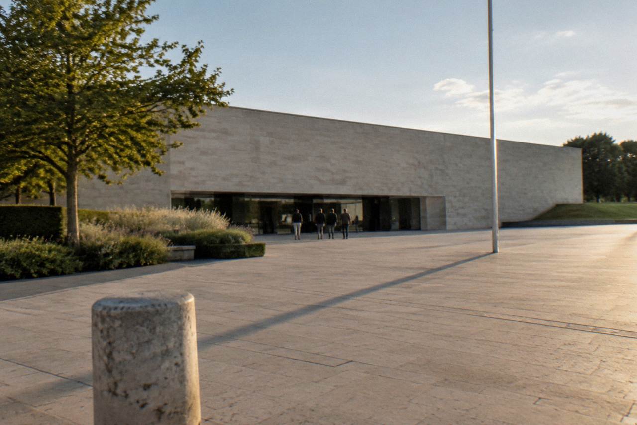 The wide stone facade of the Caen Memorial museum above its entrance esplanade