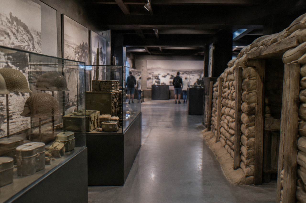 Restored military vehicles displayed inside a museum hall near Omaha Beach