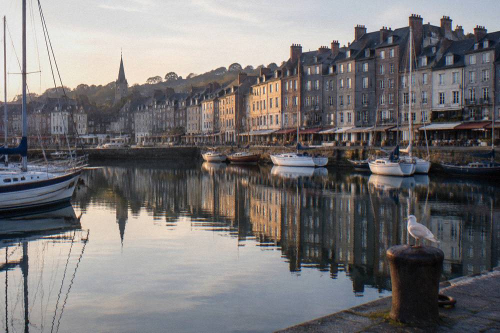 Tall narrow houses reflected in a small harbor at Honfleur