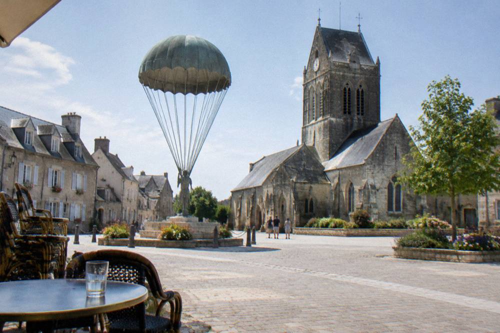 Parachute and airborne memorials in the square of a small Norman town