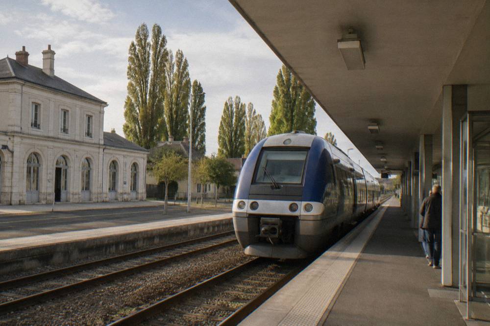 A regional train standing at a small station platform in Normandy countryside