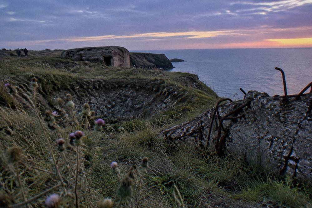 The cratered cliff top landscape of Pointe du Hoc with the English Channel beyond