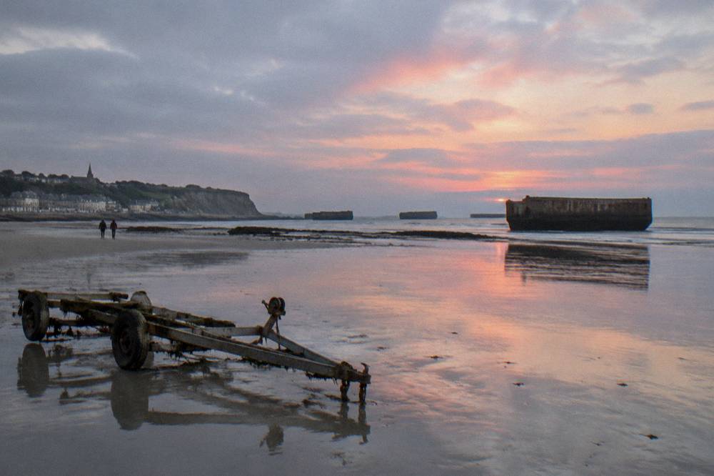 The artificial harbor remains at Arromanches visible in the water at low tide