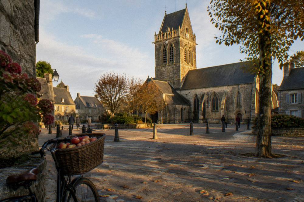Church tower and old houses around the square of Sainte-Mere-Eglise