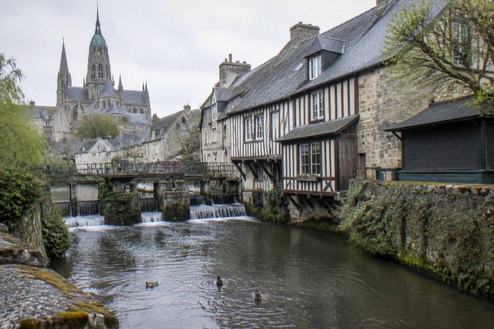 Tourist information kiosk and timber-framed buildings near the river in Bayeux