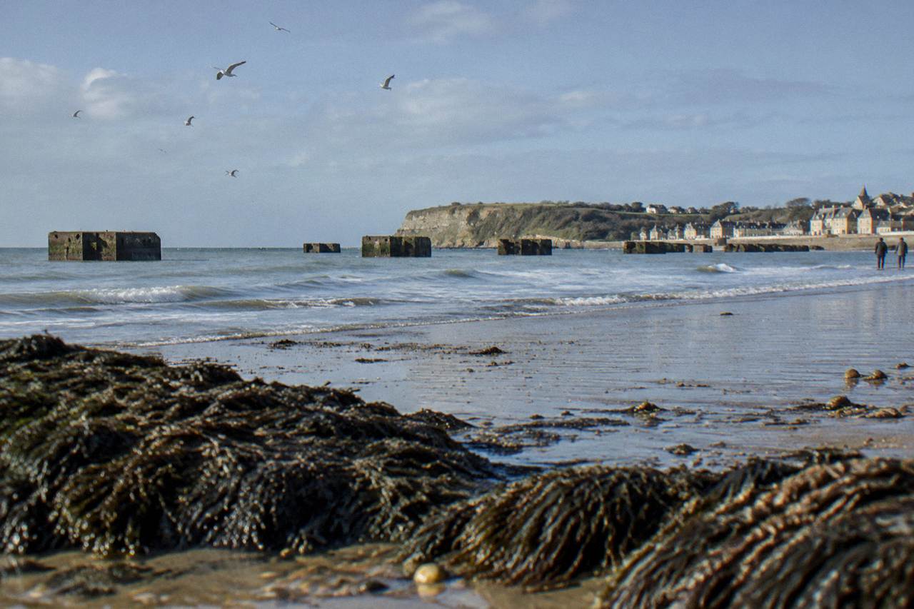 Concrete remnants of the Mulberry harbour standing in the sea off Arromanches at low tide