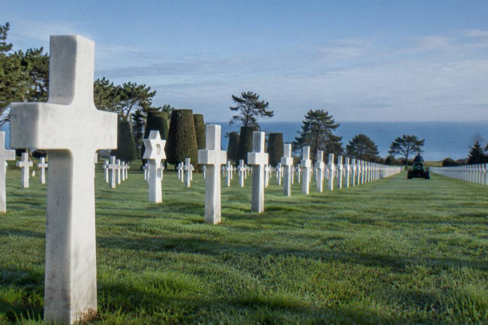 White marble crosses and Stars of David aligned in rows across a manicured lawn