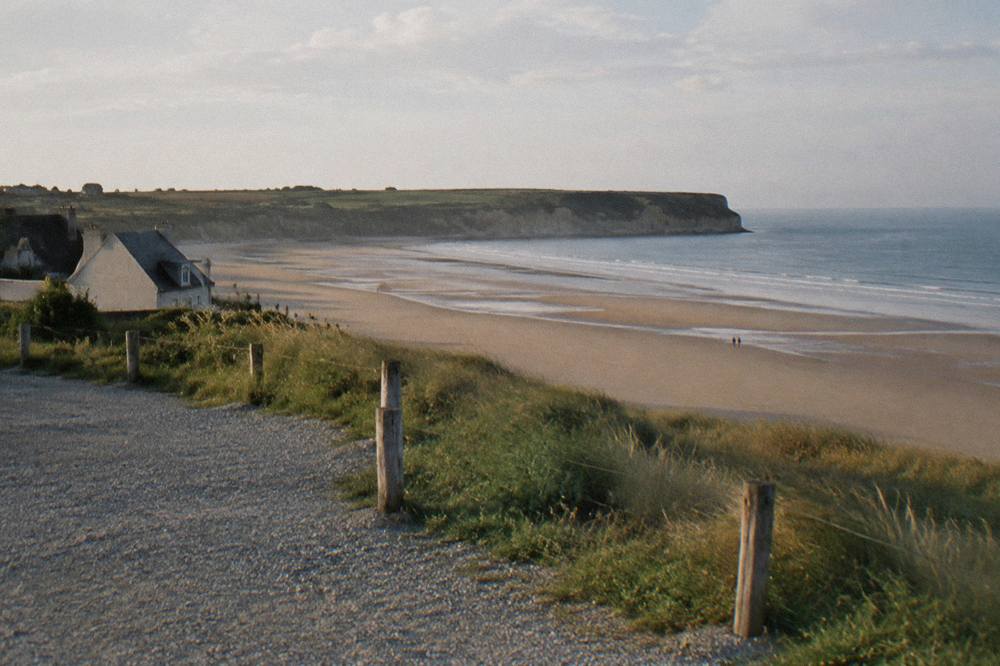 Parking area beside the seafront at Omaha Beach with the flat sandy beach stretching beyond