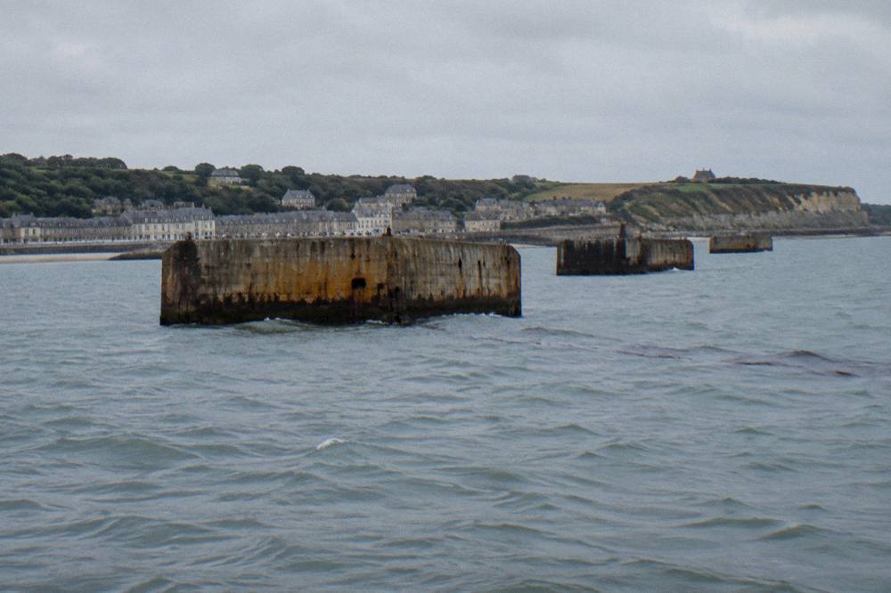 Harbor wall with remnants of wartime concrete caissons in the water