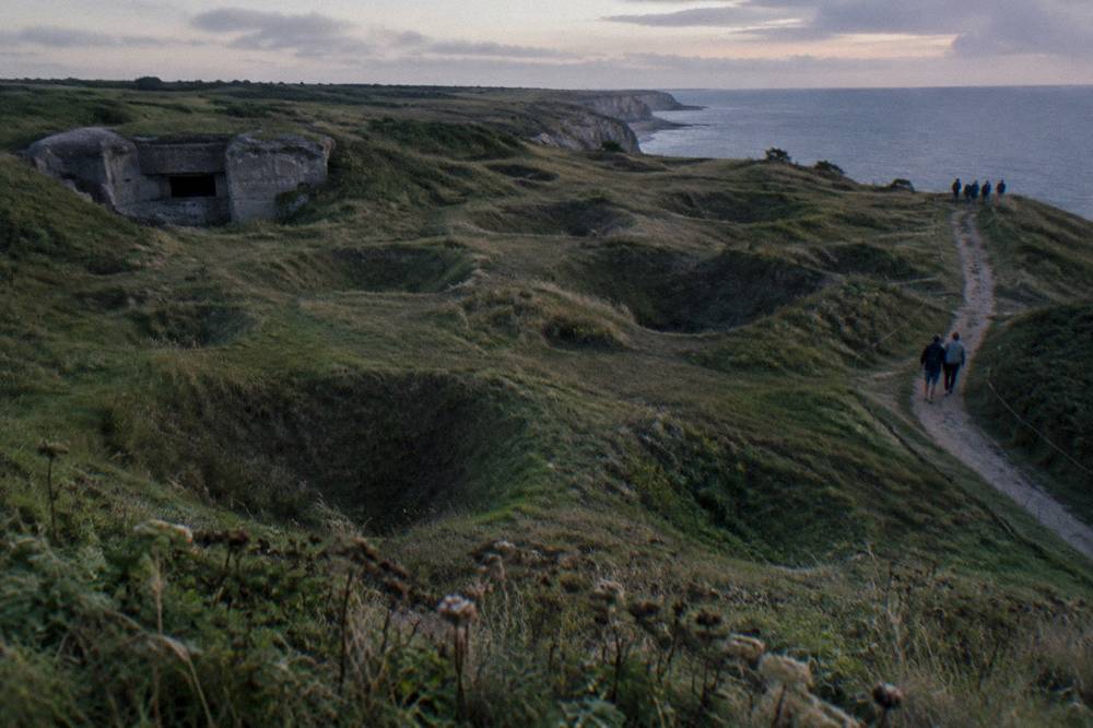 Grassed-over shell craters on the open ground at Pointe du Hoc