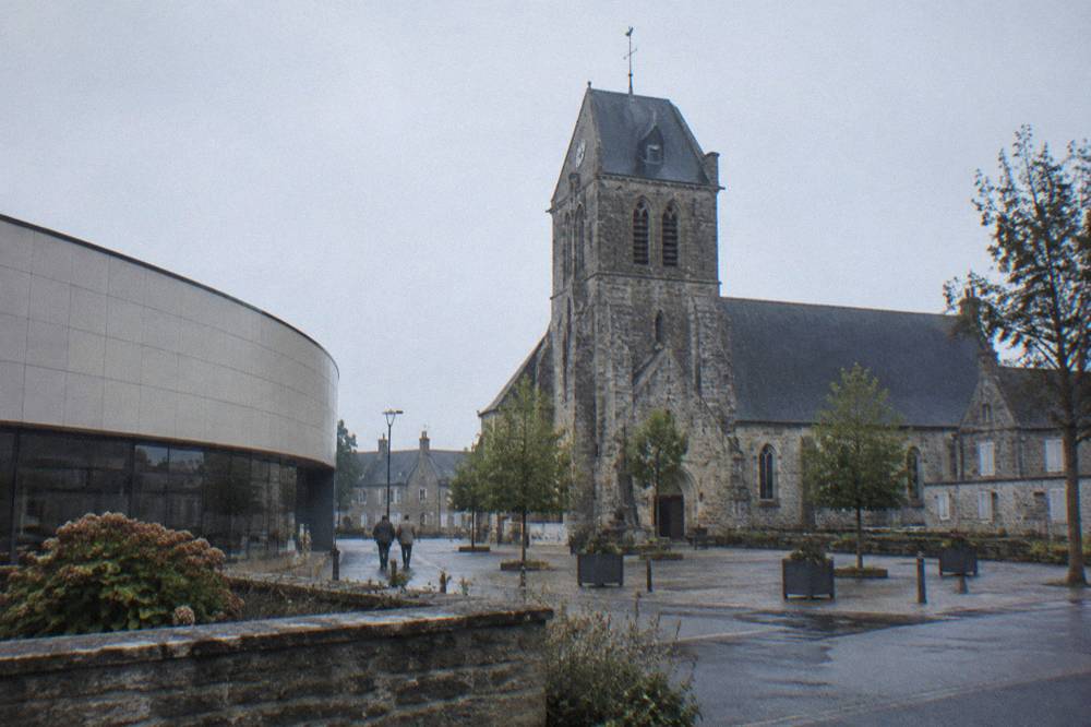 Exterior of a modern museum building beside a Norman stone church