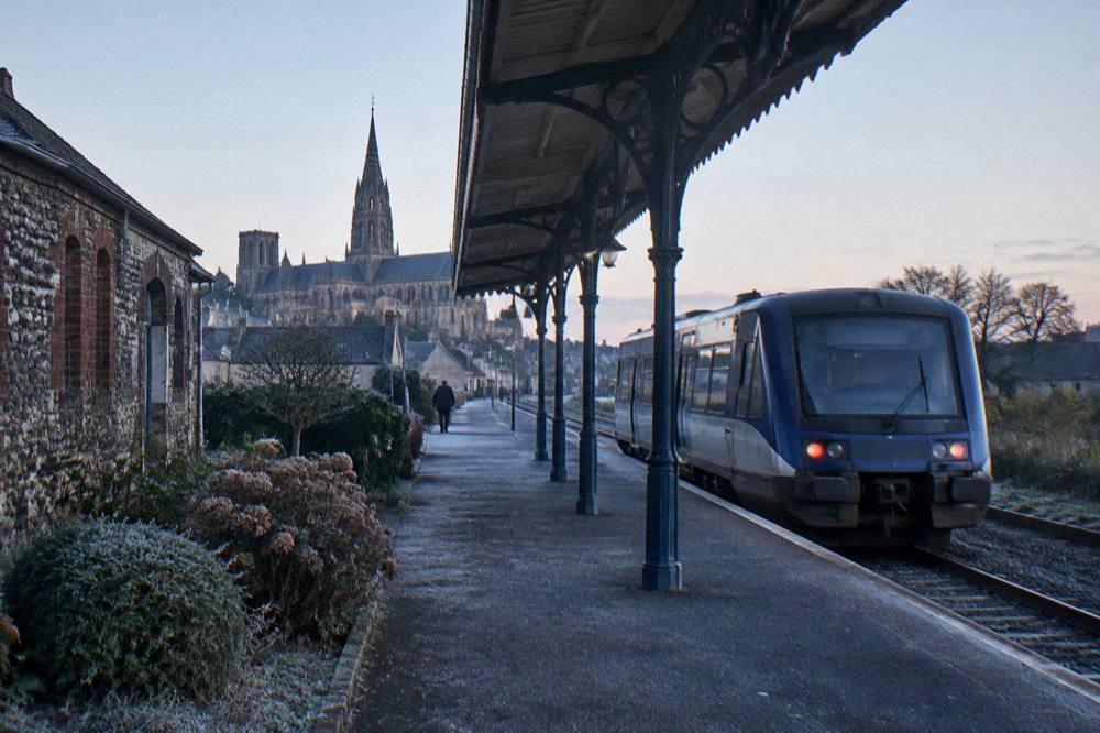 Railway station platform with a regional train at a small Norman town station