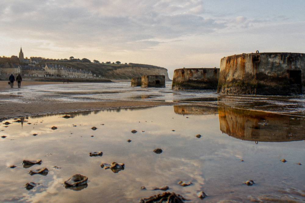 Remnants of the wartime artificial harbor standing in shallow water along a Norman shore