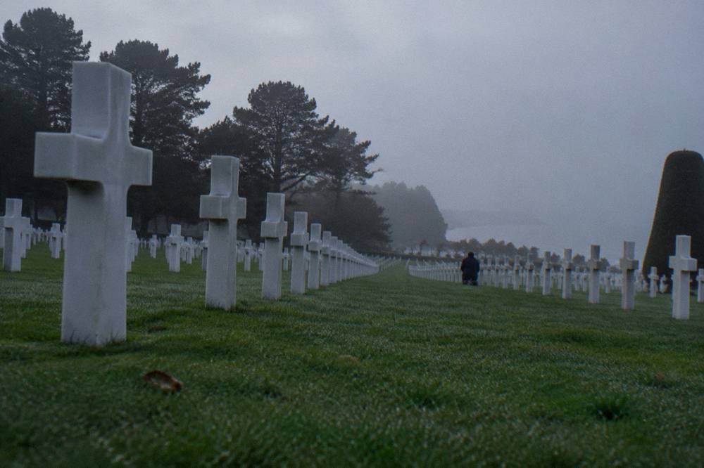 Rows of white crosses in the Normandy American Cemetery above the tree line